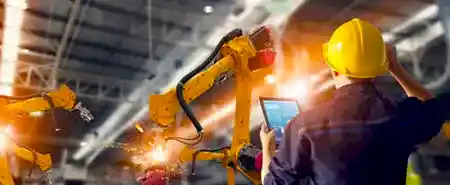 Sanayi robotlarıyla çalışan teknisyen resmi.